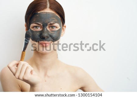 young woman clay mask with a brush 