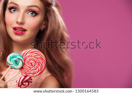 Beautiful pink lips with a sweet candy, lollypop. Close up of young woman with candy in mouth.