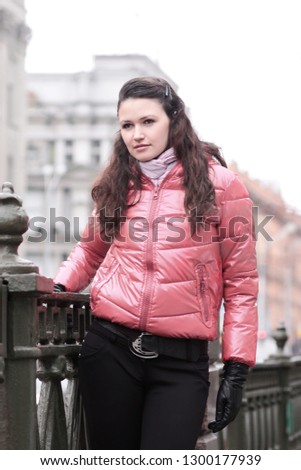 young woman standing on a bridge in the city