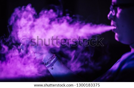 gay man smokes electronic cigarette in neon light, LGBT
