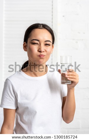 young asian woman in white t-shirt rinsing mouth with water  Royalty-Free Stock Photo #1300185724