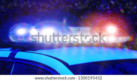 Police car with focus on siren lights at night time. Beautiful siren lights activated in full mission activity. Emergency lights flashing on patrol car.