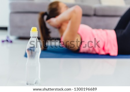 A sports young girl is diligently doing all the exercises for the press