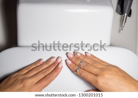 the girl in the salon shows an old manicure with regrown shellac