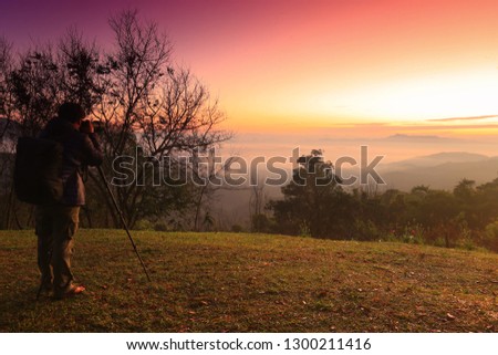 The photographer is shooting the mountain mist at sunrise.selective focus.
