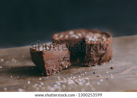 Traditional homemade chocolate cake sweet pastry dessert with brown icing, cherries, currant on vintage wooden background. Dark food photo, rustic style, natural light.