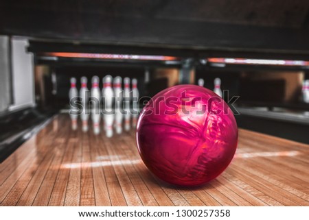 Pink bowling ball on bowling alley track.