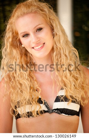 Portrait of cute blonde girl in bikini swimwear