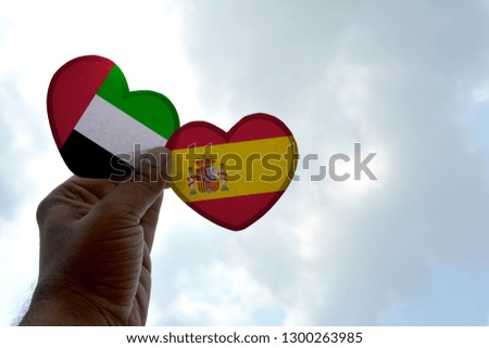 Hand holds a heart Shape UAE and Spain flag, love between two countries