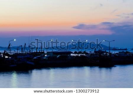 This picture is taken in the evening, in which the photo will see the sea, the harbor, the island and a twilight sky as a backdrop.