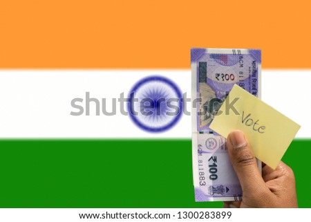 Hand holding money and vote a concept of political corruption the purchase of votes in elections background as a Indian flag
