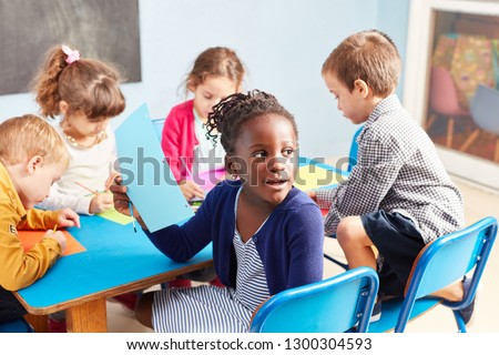 Group of kids while painting together in the drawing class in kindergarten or preschool