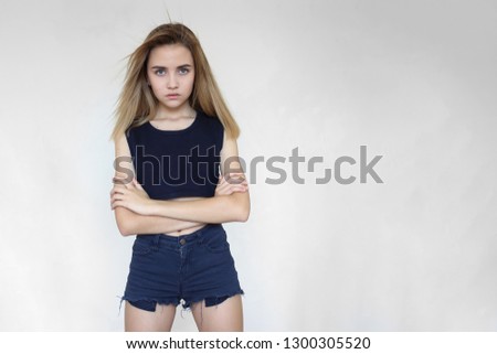young girl with piercing gaze confidently standing on a white background