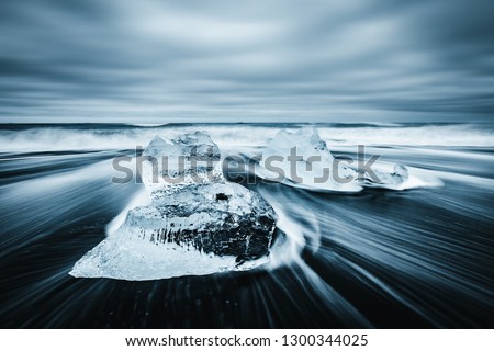 Incredible piece of the iceberg sparkle on black sand. Location Jokulsarlon lagoon, Diamond beach, Vatnajokull national park, Iceland, Europe. Long exposure photography. Discover the beauty of earth.