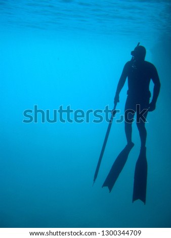 man in immersion freediving into blue of a submarine cave Royalty-Free Stock Photo #1300344709