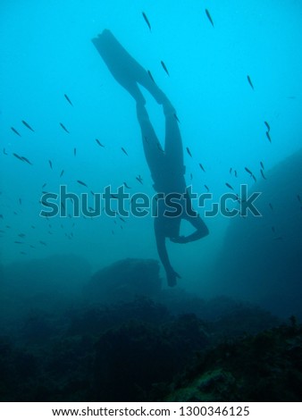 man in immersion freediving into blue of a submarine cave Royalty-Free Stock Photo #1300346125