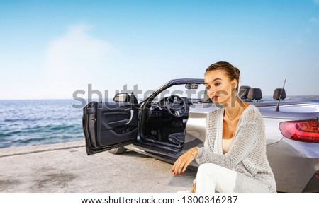 Summer car with slim young woman and silver cab on coast. Sea landscape with blue sky. 
