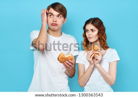 Young people with hamburgers on blue background                          