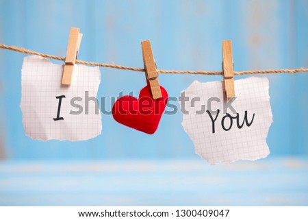 I LOVE YOU word on paper and red heart shape decoration hanging on line with copy space for text on blue wooden background. Love, Wedding, Romantic and Happy Valentine’ s day holiday concept