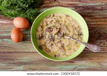 The easter composition. National Greek soup "Magiritsa" in a bowl, which is prepared once a year on Easter, on a wooden table close-up