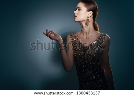 Elegant woman in evening dress and with earrings on the ears side view          