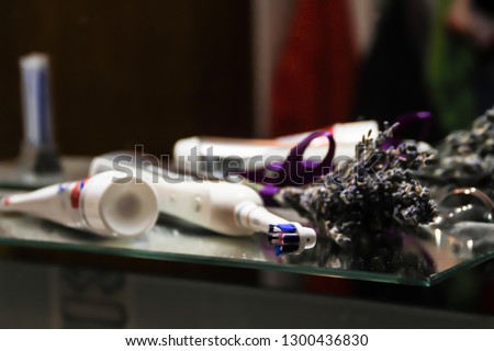 Electric toothbrush and toothpaste. Dark background. Lavender and mirror. dental care Bathroom