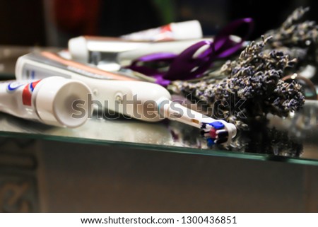 Electric toothbrush and toothpaste. Dark background. Lavender and mirror. dental care Bathroom