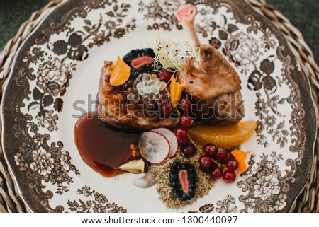 
Detail photograph of a table prepared and decorated for a party diner. Autumnal and festive decoration, with wood pineapples, candles, fruits and red colors. Lifestyle. Food photography
