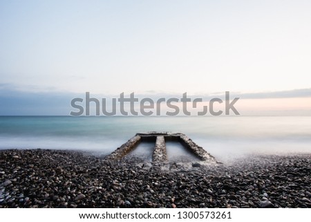 Minimalistic Sunset beach landscape with old pier.Long exposure shot.