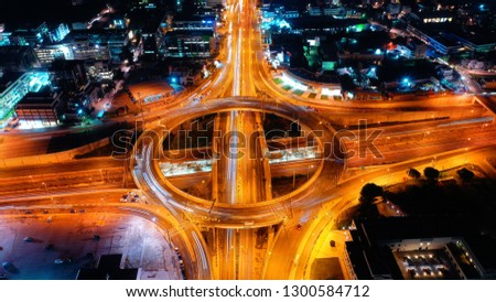 Aerial drone night slow shutter shot of multilevel junction ring road passing through city centre 