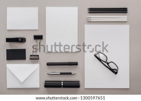 flat lay with black and white stationery and glasses at workplace on grey background