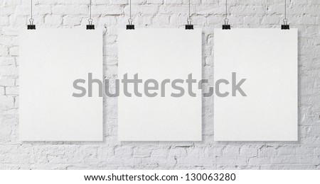 brick wall with three blank poster