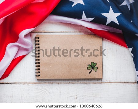 Notepad with congratulatory inscription and american star striped flag. St.Patrick's Day. Beautiful card. Close-up, wooden surface. Congratulations for loved ones, relatives, friends and colleagues