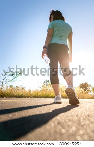Low Section Of Woman Exercising On Road