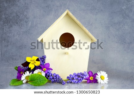 Easter card. Bird house and spring flowers on grunge background