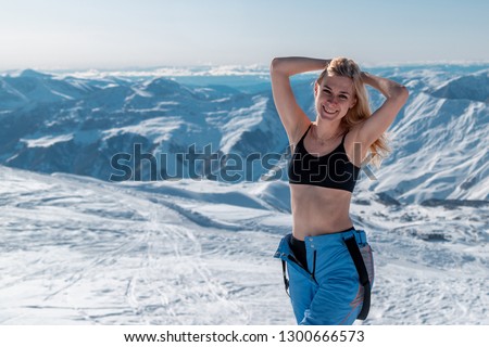 Smiling woman wearing bikini top and winter sportswear in ski resort Gudauri, Georgia