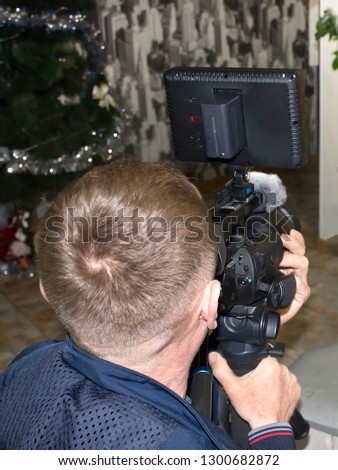 Videographer with a video camera in his hands shoots a holiday.