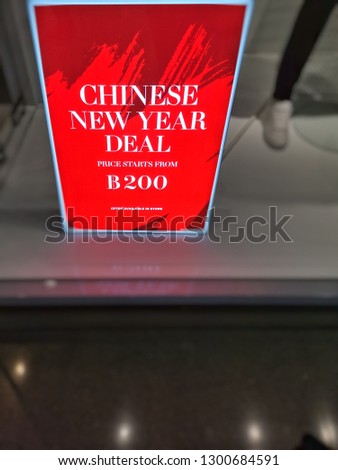red banner on display in a department store​, price​ starts from​ 200​ baht offer​ available in​ store.​Discounts on Chinese New Year's Day.Sign of sale shopping.