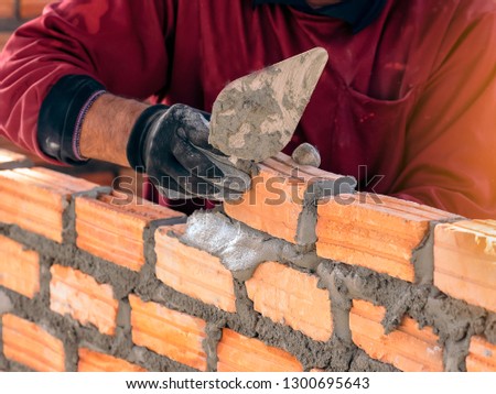 industrial Construction bricklayer worker building walls with bricks