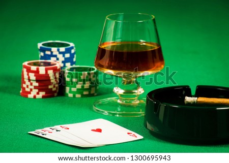 The concept of gambling, playing cards and chips with a glass of cognac and a cigar