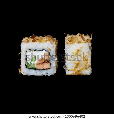 Sushi. Bonito roll with baked salmon in teriyaki sauce, cucumber, cream cheese and tuna chips, isolated in black background