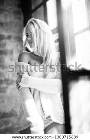 Beautiful and cute blond girl posing for photo in the loft photostudio