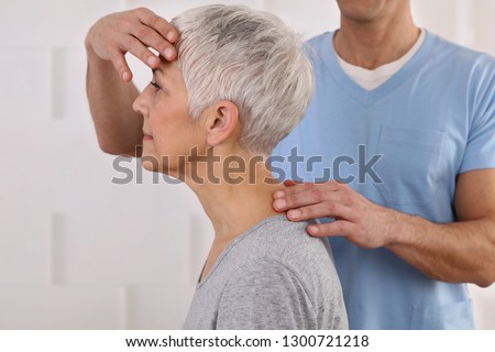 Mature Woman having chiropractic adjustment. Osteopathy, Physiotherapy, acupressure, holistic care. Craniosacral therapy Royalty-Free Stock Photo #1300721218