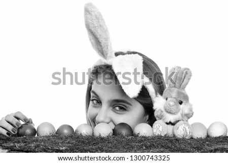 happy easter girl in pink bunny ears with smiling cute face with colorful painted eggs on green moss and rabbit toy, isolated on white background. traditional spring holiday food