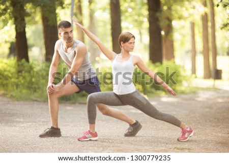 Beautiful happy couple doing together stretching exercises 