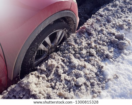 car wheel on the side of the road, can not drive. the situation on the streets after a snow cyclone. bad service by communal department in ukraine and russia. dirty dust in kiev.