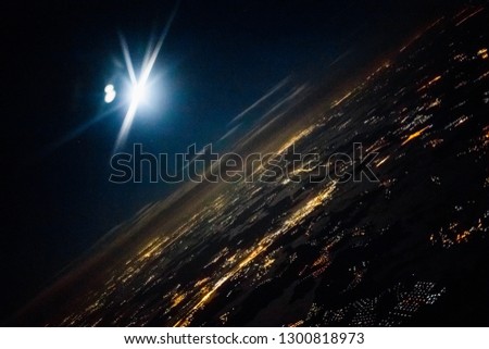 view from the airplane night moon. view from the plane of the night moon. Flying over the city, aerial shot. Small cities shine at night.