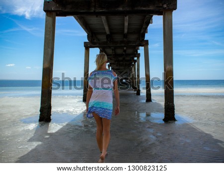 Happy traveller woman in blue dress enjoys her tropical beach vacation, Australia
