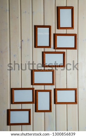  empty photo frames and paintings on the background of a wooden wall                              