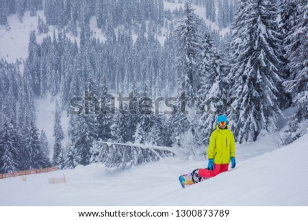 Happy girl snowboarder having fun in the winter ski resort.